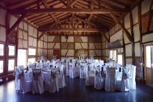 une salle remplie de tables avec des chaises blanches dans l'établissement Domaine des Brouilles, à Malafretaz