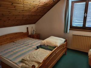 a bedroom with a wooden bed and a window at Weingarten-Haus in Klöch