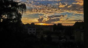 een zonsondergang in een stad met wolken in de lucht bij Melia in Hamm