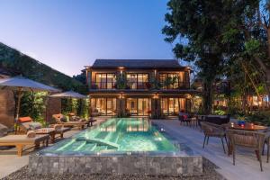 une maison avec une piscine devant une maison dans l'établissement Pai Village Boutique Resort, à Pai