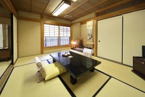 ein großes Wohnzimmer mit einem Tisch und Stühlen in der Unterkunft Yadoya Kikokuso in Kyoto