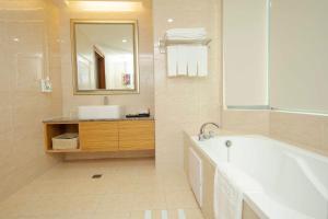 a bathroom with a tub and a sink and a mirror at Arsma Hotel in Hualien City