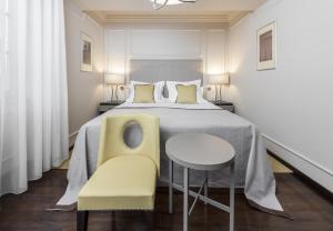 a bedroom with a bed and a table and chairs at Bastion Heritage Hotel - Relais & Ch&acirc;teaux in Zadar