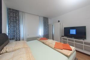 a bedroom with two beds and a flat screen tv at Restaurant Trocadero in Hannover