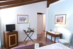 a living room with a tv and a chair and a table at Il Bagattino in Ferrara