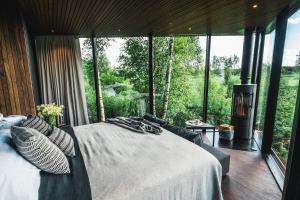 sypialnia z dużym łóżkiem i dużym oknem w obiekcie Maidla Nature Resort w mieście Maidla