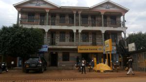 un grande edificio con persone di fronte di Highway Motel a Nebbi