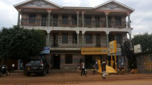 a large building with people walking in front of it at Highway Motel in Nebbi