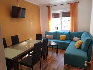 sala de estar con sofá azul y mesa en Homelunead Apartamento en Gijon Centro al lado de la Playa, en Gijón