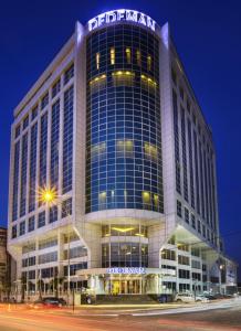 un grand bâtiment avec un panneau en haut dans l'établissement Dedeman Erbil Hotel City Center, à Erbil