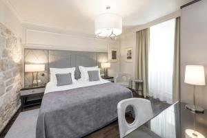 a bedroom with a large bed and a large window at Bastion Heritage Hotel - Relais & Ch&acirc;teaux in Zadar