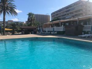 a large blue swimming pool in front of a building at La Mata Beach - Studio - Appartement - Miramar XI - Torrevieja in Torrevieja