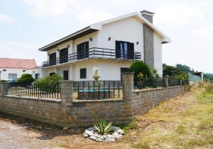 a house behind a brick fence at Granja MG in Bombarral