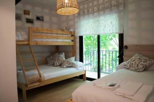 a bedroom with two bunk beds and a window at Latas Surf Lodge in Loredo
