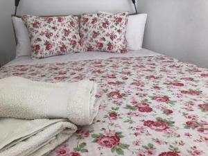 a bed with a floral blanket and pillows on it at Casa Sinclair in El Colmenar