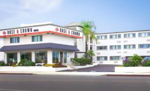 een wit gebouw met een bord dat zegt gewoon am bij Pasadena Rose & Crown Hotel in Pasadena