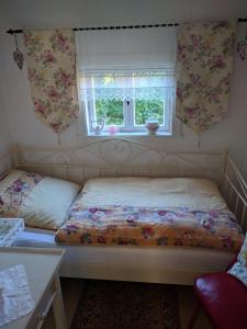 a small bedroom with a bed and a window at Ferienhaus Johanna & Ferienwohnung Thum in Weischlitz