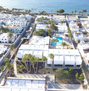 an aerial view of a resort with palm trees and the ocean at Orly Club Coral Arena Dorada in Puerto del Carmen