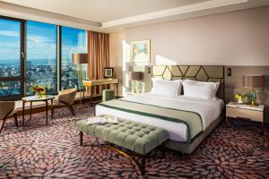 ソフィアにあるGrand Hotel Millennium Sofiaのベッドと大きな窓があるホテルの部屋