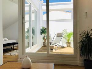 ein Zimmer mit einer Glasschiebetür mit einem Stuhl im Freien in der Unterkunft Apartamentos La Bola Suite in Ronda