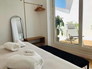 een slaapkamer met een bed met handdoeken erop bij Apartamentos La Bola Suite in Ronda