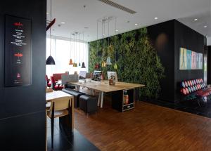 an office with a table and a green wall at citizenM Paris Charles de Gaulle Airport in Roissy-en-France