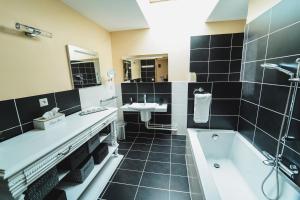 a bathroom with a bath tub and a sink and a bath tub at Ô Rethel Jacuzzi, Gîte Ardennes in Rethel +54 photos