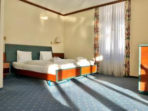 a hotel room with two beds and two lamps at Thermal Hotels & Walliser Alpentherme Leukerbad in Leukerbad