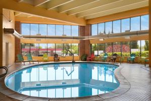 uma piscina no átrio do hotel com cadeiras e mesas em Howard Johnson by Wyndham South Portland em South Portland