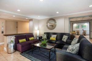 a living room with couches and a table at La Quinta by Wyndham Melbourne Viera in Melbourne