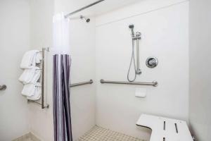 a white bathroom with a shower and a sink at La Quinta by Wyndham Melbourne Viera in Melbourne