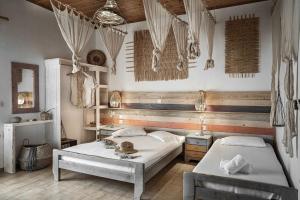 a bedroom with two beds and a wooden wall at Kanela Studios in Alykes