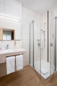 a bathroom with a glass shower and a sink at ClassicX Landhaus & Hotel - Bed & Breakfast in Gensingen