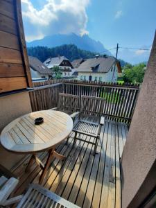 a wooden deck with a table and chairs on a balcony at House Neza in Kranjska Gora