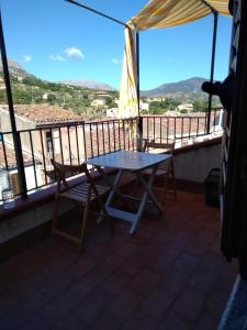una mesa y sillas en un balcón con vistas en Casa Levante, en Castelbuono