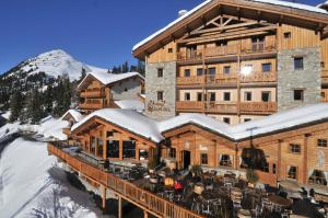 a cabin with a ski lodge and a mountain range at Hôtel Carlina by Les Etincelles in Belle Plagne