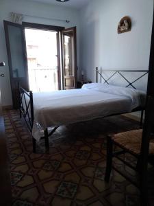 a bedroom with a bed in a room with a window at Casa Levante in Castelbuono