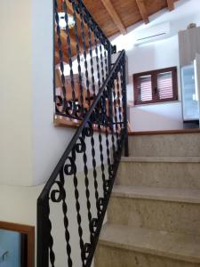 un escalier avec une balustrade à motifs noir et blanc dans l'établissement Casa Levante, à Castelbuono