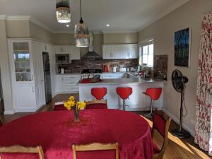 a kitchen with a table with a red table cloth at Mountain Blue Guest House in Deloraine