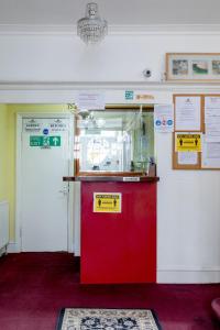 a red refrigerator in a room with signs on the wall at Euro Hotel Harrow in Harrow