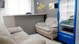 a living room with a couch and two chairs at Hotel Bella Júlia in Joinville