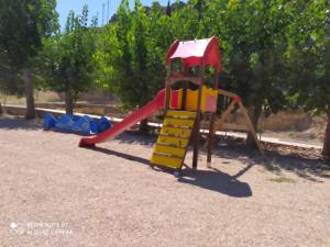 un patio de recreo con un tobogán en un parque en Apartamentos rurales La posada de Donato, en Nuévalos