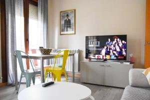 a living room with a tv and a table and chairs at Dúplex Casa Lis-En pleno corazón de la ciudad- in Salamanca