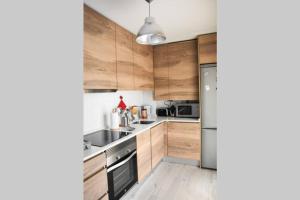a kitchen with wooden cabinets and stainless steel appliances at Dúplex Casa Lis-En pleno corazón de la ciudad- in Salamanca