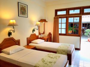a hotel room with two beds and a window at Peti Mas Hotel Malioboro in Yogyakarta