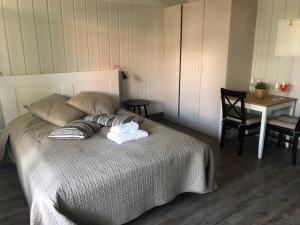 1 dormitorio con 1 cama con 2 almohadas y mesa en Preiliai apartments, en Preila