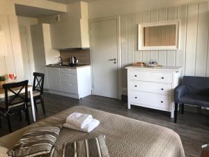 a room with a bed and a kitchen with a table at Preiliai apartments in Preila