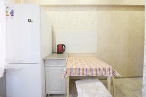 una pequeña cocina con mesa y nevera en Presnensky Val Apartment, en Moscú