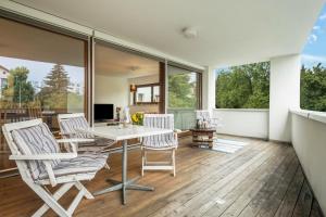 a living room with a table and chairs and windows at Ferienwohnung Felix in Bregenz