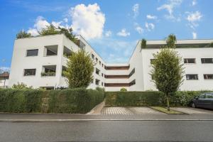 a white building with trees in front of it at Ferienwohnung Felix in Bregenz